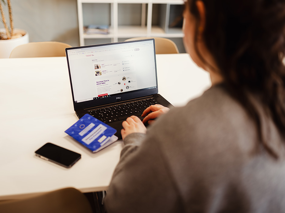 Eine Person sitzt vor einem Laptop und nutzt die MeinTASSO-Seite für Suchhelfer.