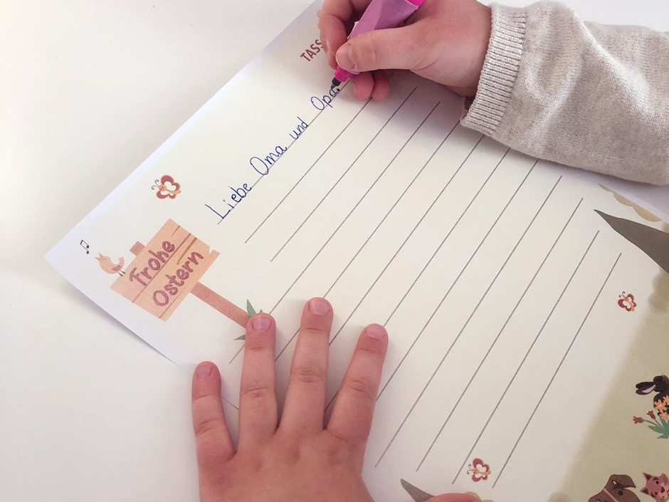 Ein Kind schreib mit der TASSO-Briefvorlage einen Brief an ihre Oma und ihren Opa.